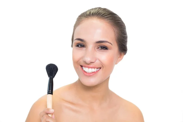 Cheerful young woman holding a powder brush — Stock Photo, Image