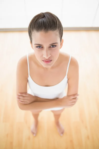 Woman in white sportswear posing with crossed arms — Stock Photo, Image