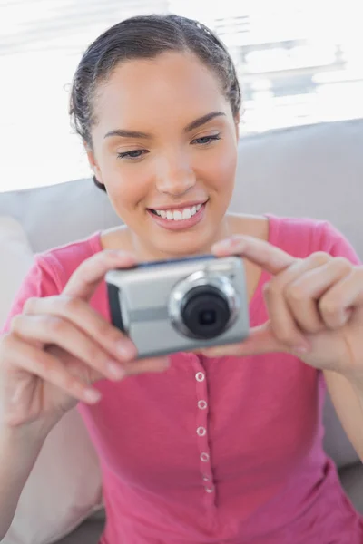 Happy woman sitting on sofa and taking a picture — Stock Photo, Image