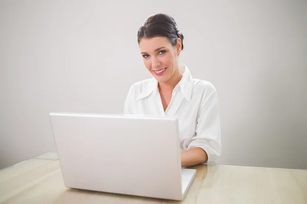 Smiling charming businesswoman typing on laptop Royalty Free Stock Photos