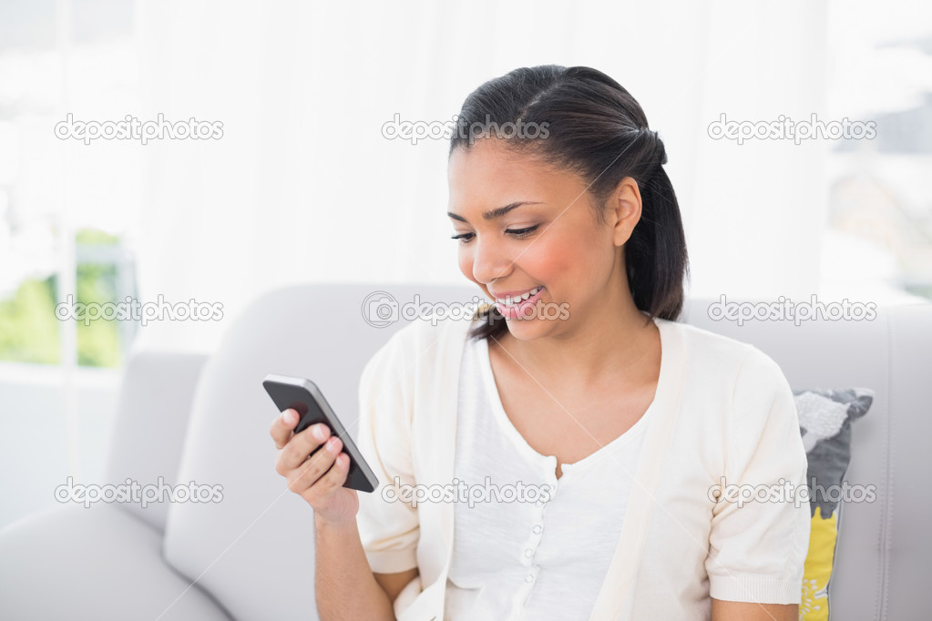Young woman in white clothes looking at her mobile phone