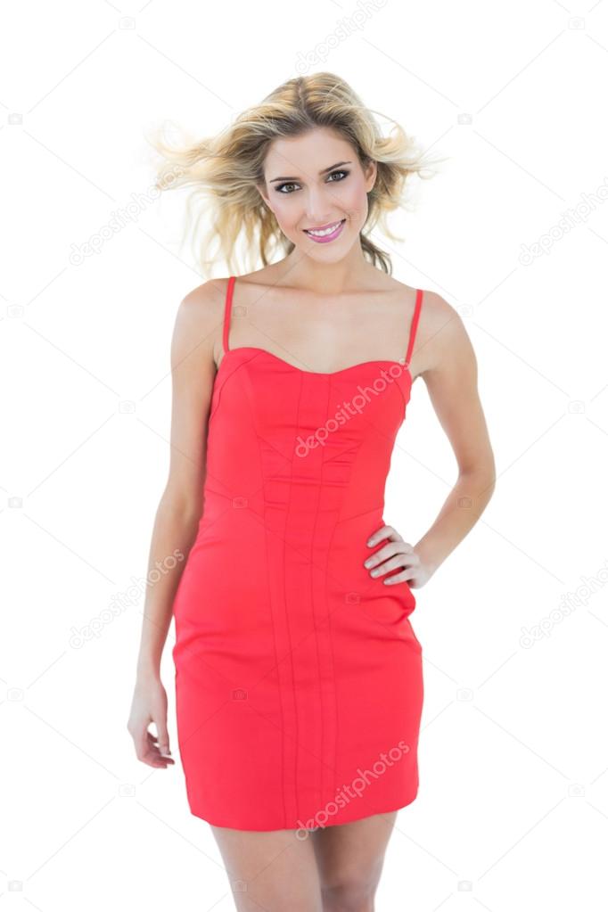 Happy smiling blonde model posing with hand on hips