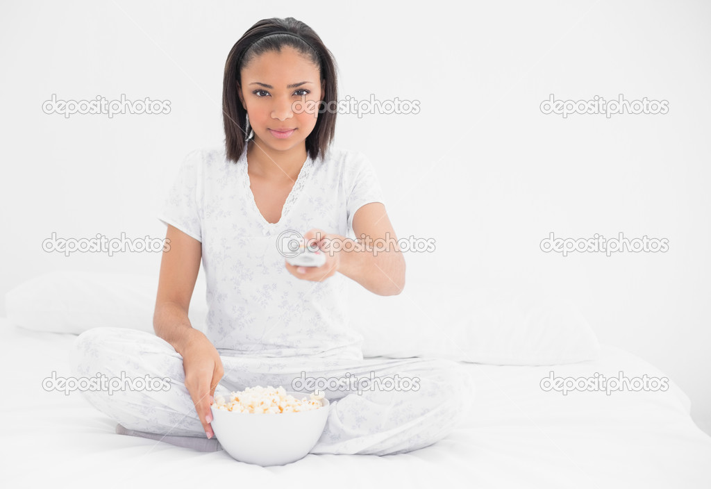 Relaxed young model eating popcorn