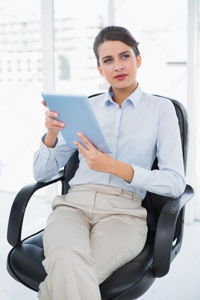 Thoughtful businesswoman using a tablet pc