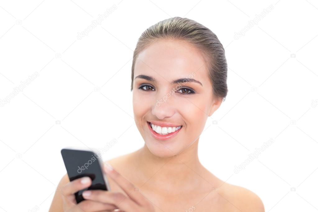 Cheerful young woman holding a smartphone