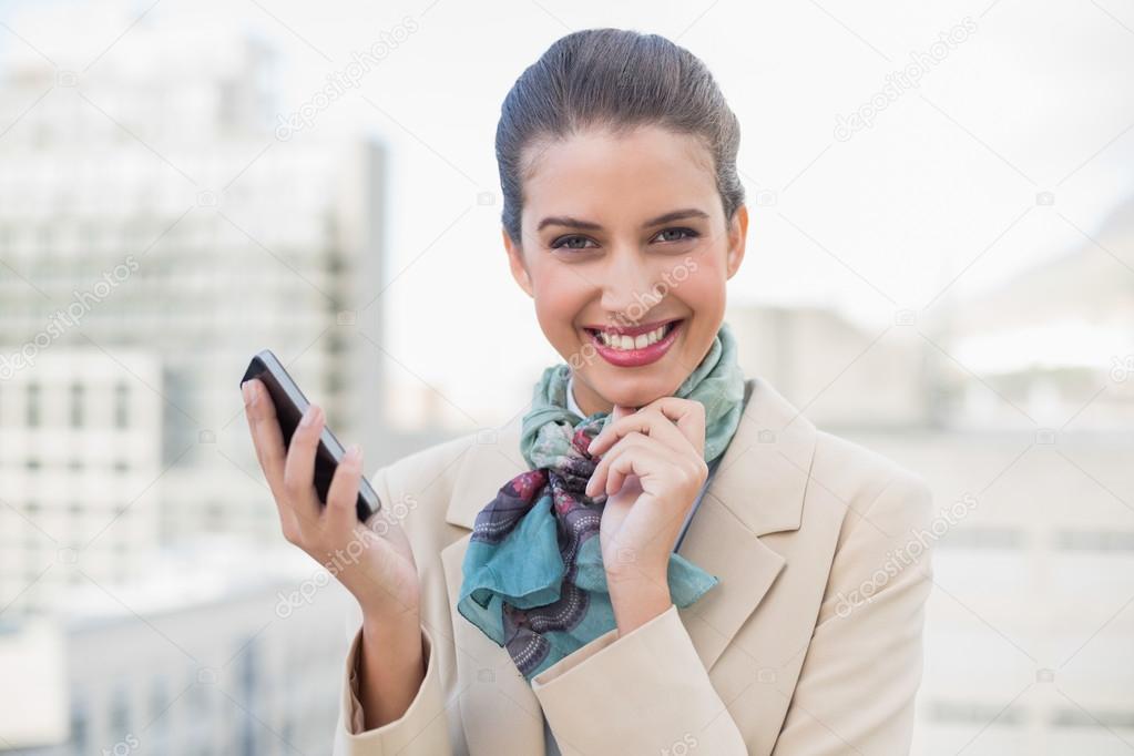 Delighted businesswoman holding a mobile phone