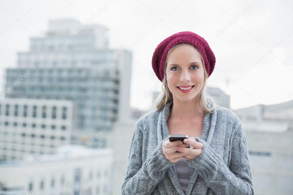 Happy pretty blonde text messaging outdoors