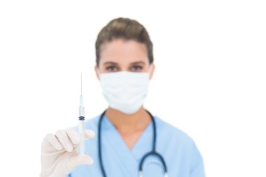 koruma maske ve bir şırınga tutarak mavi güzel hemşire scrubs