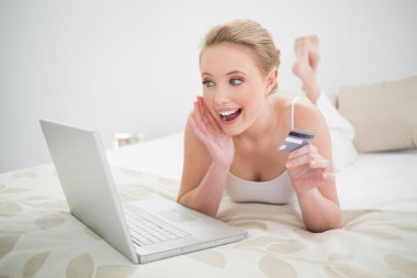 kredi kartı tutan ve laptop arıyorum doğal heyecanlı sarışın