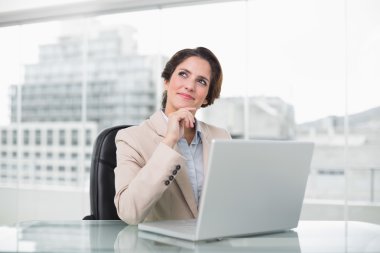 düşünceli işkadını masasında dizüstü kullanarak