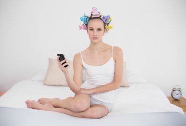 papatyanın saçı curlers bir cep telefonu tutan kadında