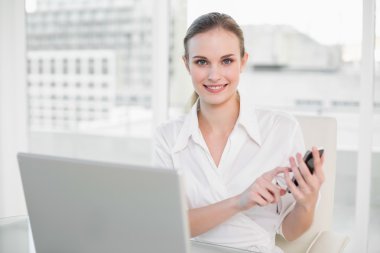 dizüstü bilgisayar, mesaj smartphone kullanarak iş kadını gülümseyen