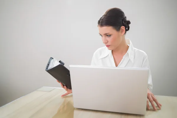 Preciosa mujer de negocios trabajando en portátil celebración de agenda — Foto de Stock