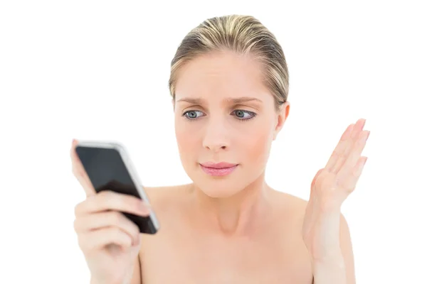 Puzzled fresh blonde woman looking at her mobile phone — Stock Photo, Image