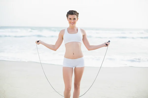 Smiling slim model playing with a skipping rope — Stock Photo, Image