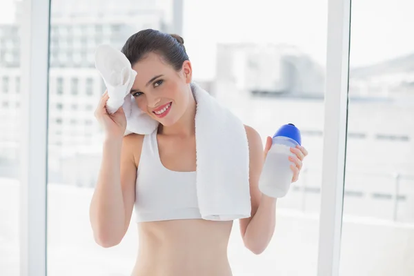 Modelo de ajuste cansado en ropa deportiva limpiando su frente con una toalla —  Fotos de Stock