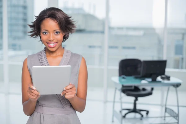 Glimlachende zakenvrouw permanent in haar kantoor en houden van Tablet PC — Stockfoto