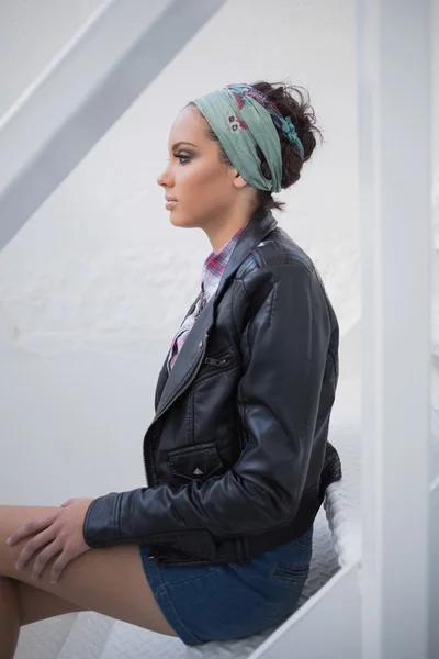 Серьёзная женщина с резинкой для волос сидит на лестнице — стоковое фото