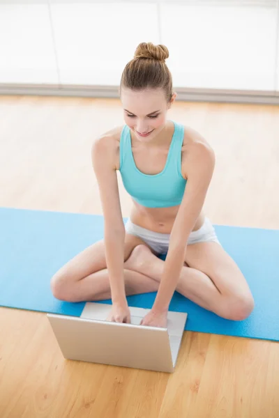 Sporty cheerful woman using laptop — Stock Photo, Image