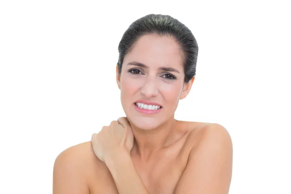 Troubled bare brunette touching her neck — Stock Photo, Image