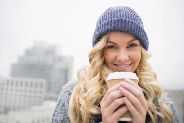 Веселая симпатичная блондинка пьет кофе на открытом воздухе — стоковое фото