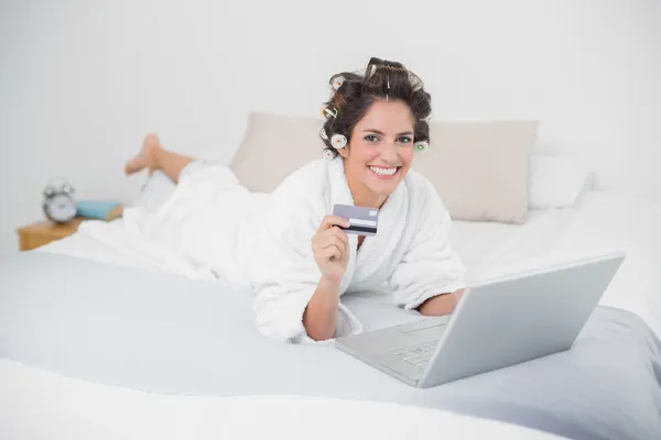 Smiling natural brunette using credit card and laptop — Stock Photo, Image