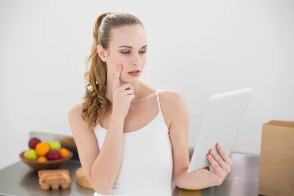 Doordachte jonge vrouw met behulp van haar digitale Tablet PC — Stockfoto