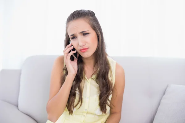 Smutný mladé černovlásky drží mobilní telefon — Stock fotografie