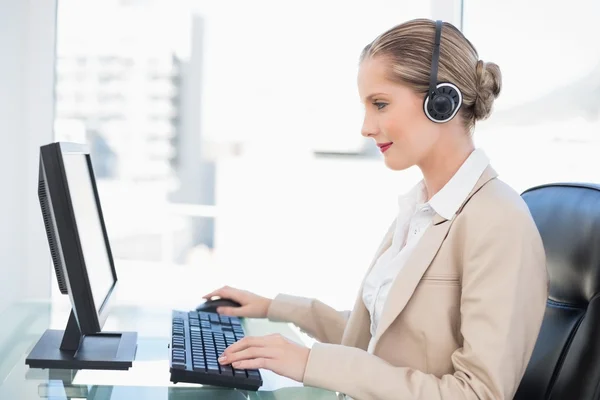 Leende blondin call centre agent som arbetar på dator — Stockfoto