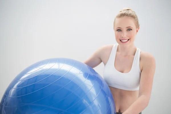 Sorridente bionda sportiva che tiene palla esercizio — Foto Stock