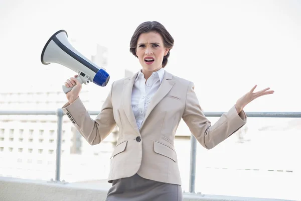 Раздражительная стильная деловая женщина с мегафоном — стоковое фото