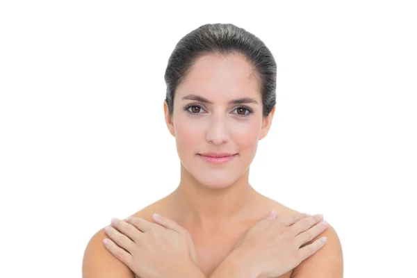 Smiling bare brunette touching both shoulders — Stock Photo, Image