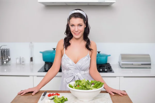 Smiling pretty brunette making salad — Stock Photo, Image