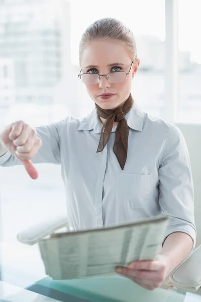 Zakenvrouw krant bedrijf en duim omlaag tonen — Stockfoto