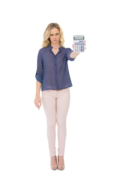 Frowning pretty blonde showing calculator — Stock Photo, Image