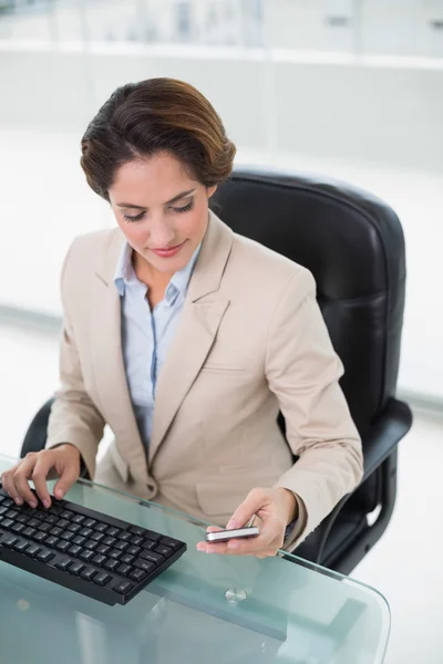 Zufriedene Geschäftsfrau schaut aufs Smartphone — Stockfoto