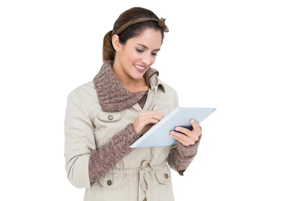 Uśmiechający się ładny brunetka w zimowe moda za pomocą tabletu — Zdjęcie stockowe