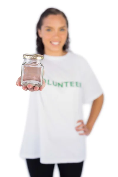 Smiling volunteer woman showing jar — Stock Photo, Image