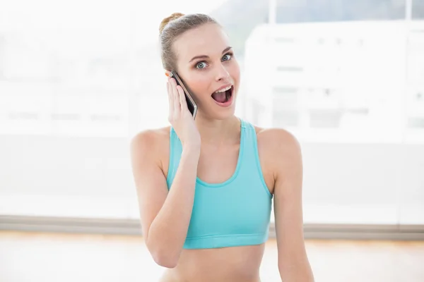 Desportivo surpreendido mulher telefonar — Fotografia de Stock