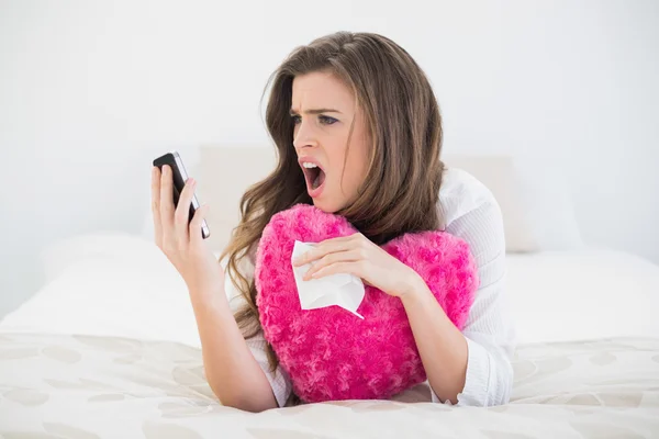 Angry woman in white pajamas hanging up her mobile phone — Stock Photo, Image