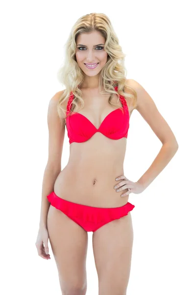 Attractive smiling blonde model posing with hand on hips wearing bikini — Stock Photo, Image