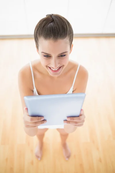 Vrouw in wit sportkleding met behulp van een tablet pc — Stockfoto