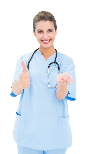 Joyeuse infirmière en blouse bleue conseillant une pilule — Photo