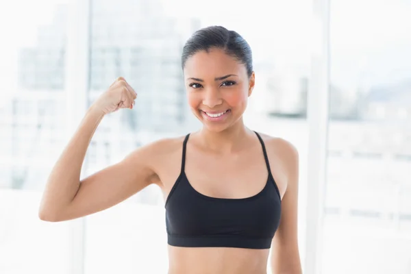 Happy model in sportswear contracting her muscles — Stock Photo, Image