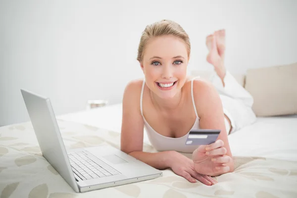 Natural cheerful blonde holding credit card — Stock Photo, Image