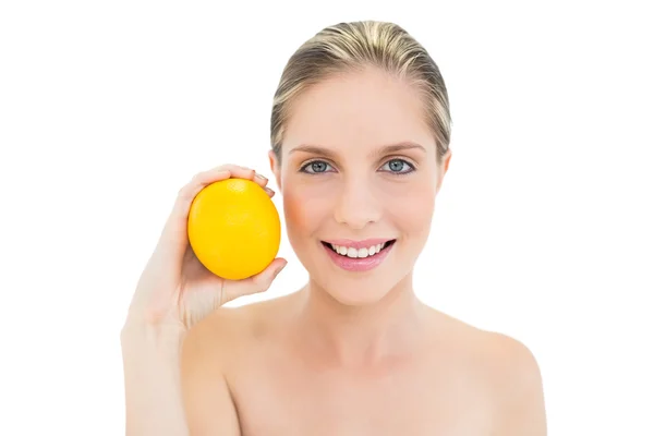 Sonriente mujer rubia fresca sosteniendo una naranja —  Fotos de Stock