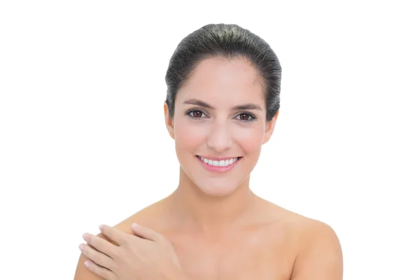 Smiling bare brunette touching left shoulder — Stock Photo, Image