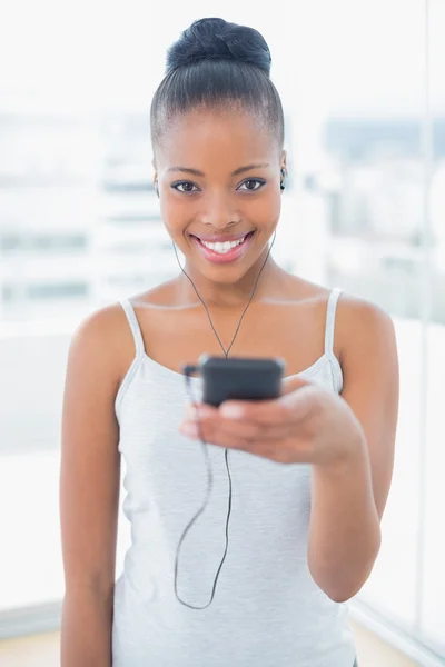 Happy attractive model in sportswear listening to music — Stock Photo, Image