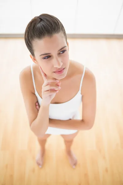 Femme pensante en vêtements de sport blancs posant les yeux ailleurs — Photo