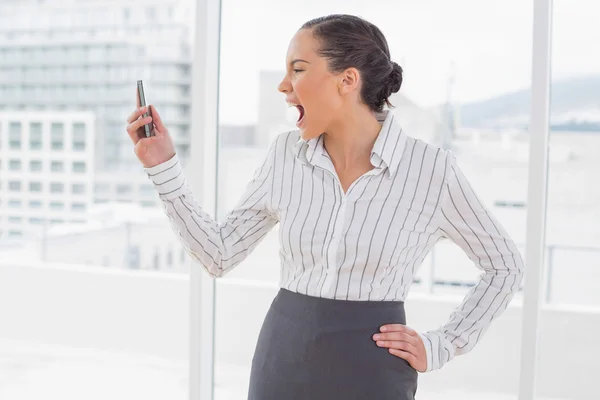 Angry businesswoman screaming at her phone — Stock Photo, Image